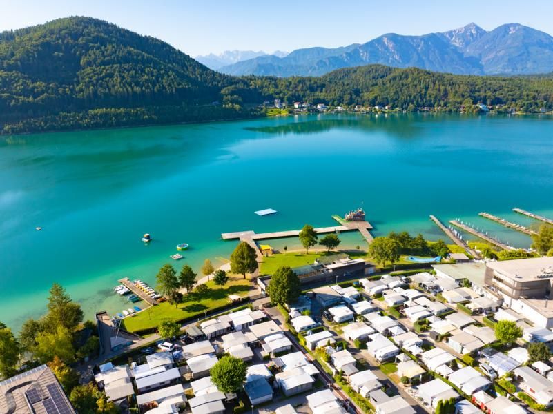 Luftaufnahme: Campingplatz Nord am Ufer des türkisen Klopeiner Sees, im Hintergrund Berge